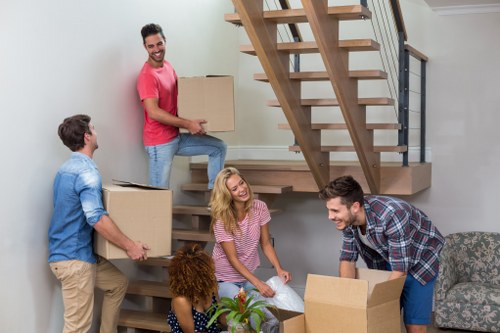 Removal team using safe lifting practices during a house move
